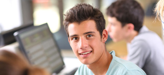 Estudiante en el aula, mirando a cámara