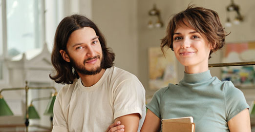 pareja en su oficina sonriente mirando a cámara 