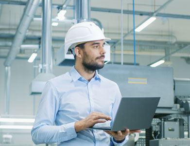 chico en fábrica con ordenador