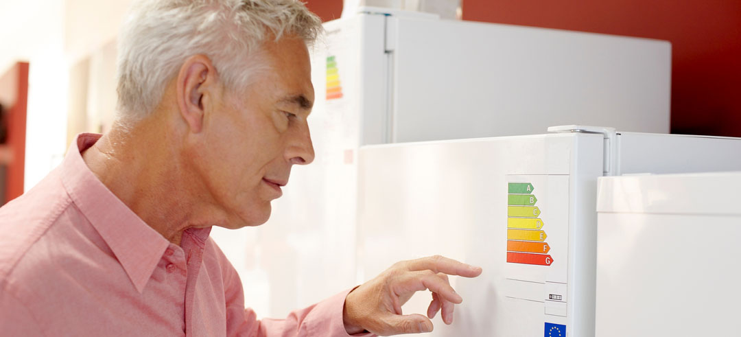 Hombre leyendo una etiqueta de eficiencia energética de un electrodoméstico