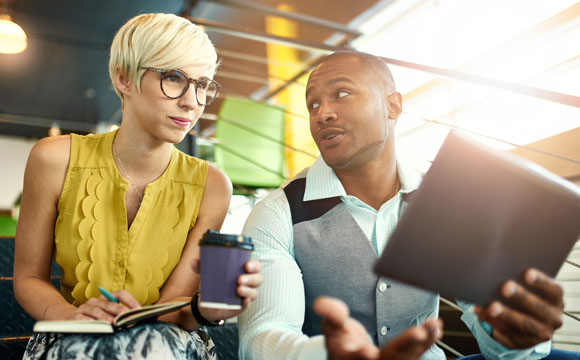 dos jóvenes mirando el ordenador en oficinas modernas