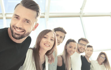 trabajadores en fila mirando a cámara